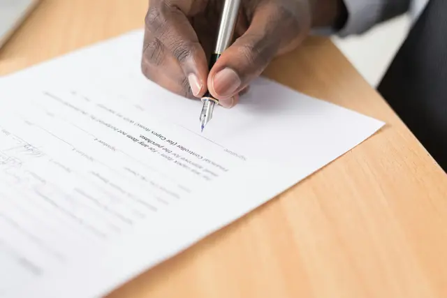A modern, organized workspace with a man signing a deal, symbolizing efficiency in M&A deal flow.